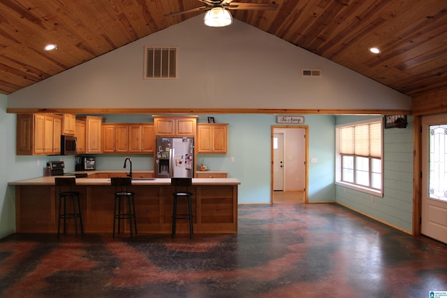 kitchen with ceiling fan, appliances with stainless steel finishes, high vaulted ceiling, a breakfast bar, and sink