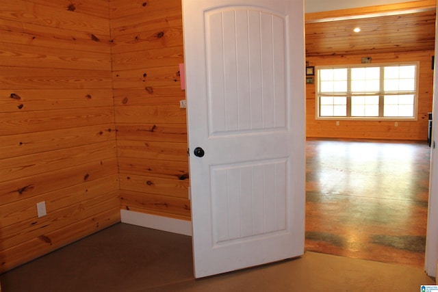 unfurnished room featuring wooden walls