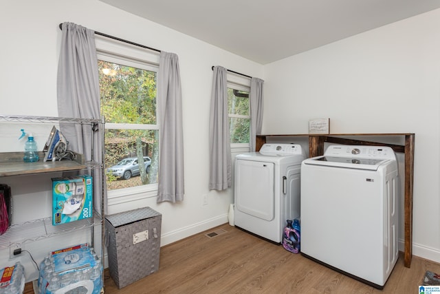 washroom with light wood-type flooring and washing machine and clothes dryer