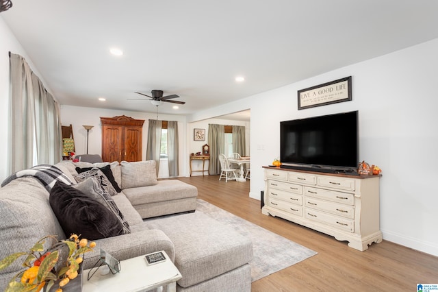 living room with light hardwood / wood-style floors and ceiling fan