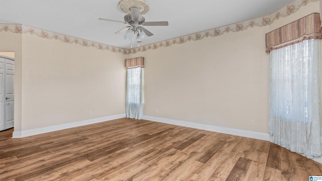 empty room featuring hardwood / wood-style floors, a healthy amount of sunlight, and ceiling fan