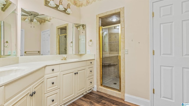 bathroom with a shower with door, vanity, hardwood / wood-style floors, and ceiling fan