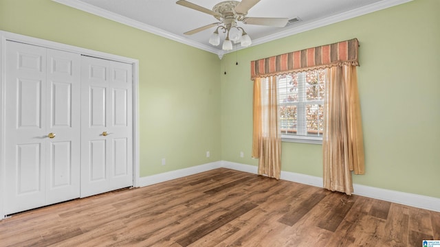 unfurnished bedroom featuring a closet, ceiling fan, ornamental molding, and wood-type flooring