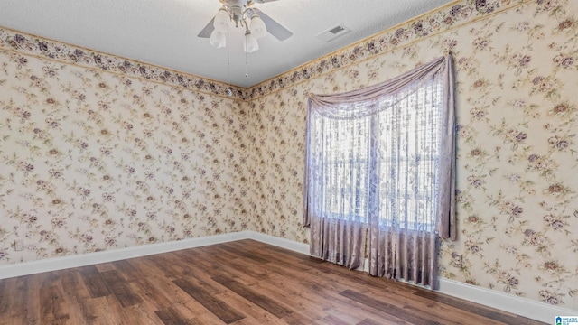 spare room with a textured ceiling, hardwood / wood-style flooring, and ceiling fan