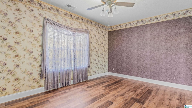 unfurnished room featuring a healthy amount of sunlight, hardwood / wood-style flooring, and a textured ceiling