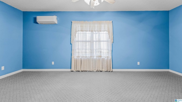 carpeted empty room featuring an AC wall unit, a textured ceiling, and ceiling fan