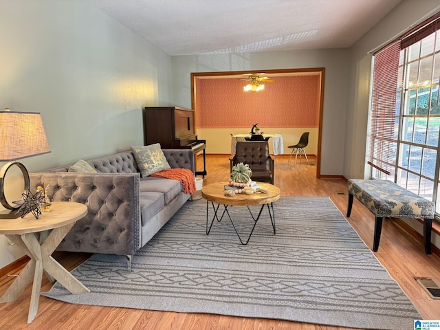 living room with light wood-type flooring and ceiling fan