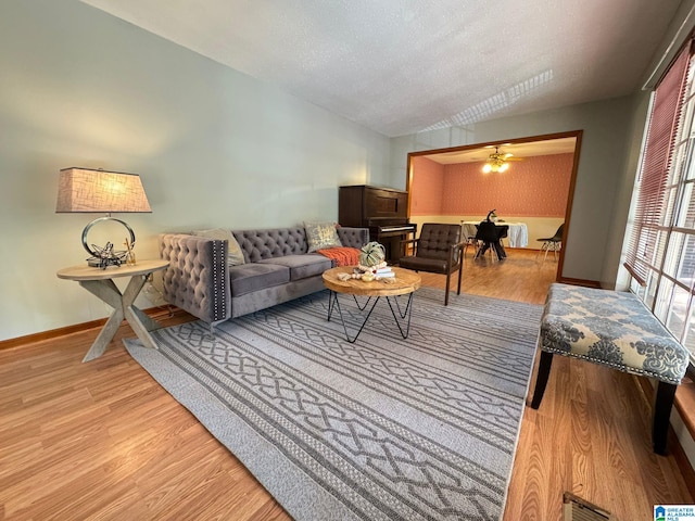 living room with a textured ceiling, light hardwood / wood-style flooring, and vaulted ceiling