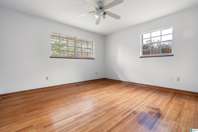 spare room with hardwood / wood-style flooring, ceiling fan, and plenty of natural light