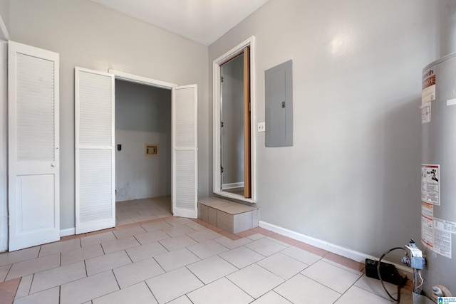 unfurnished bedroom with electric panel, light tile patterned flooring, and water heater