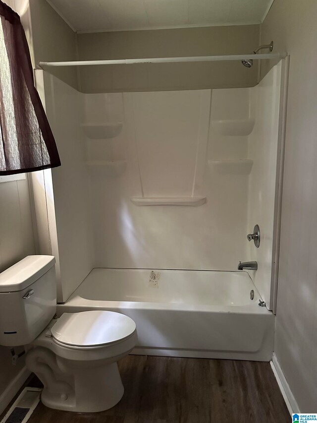 bathroom with toilet, hardwood / wood-style floors, and tub / shower combination