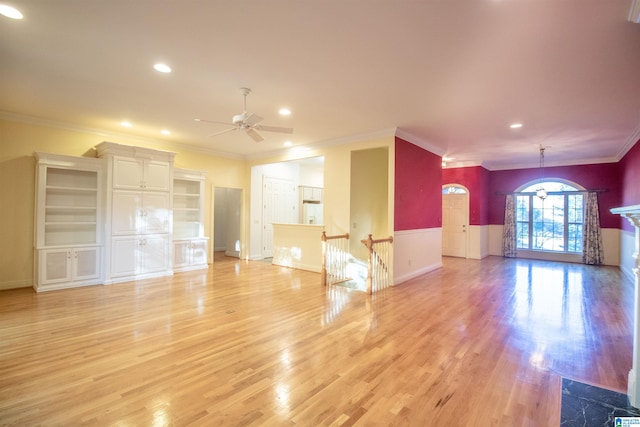 unfurnished living room featuring light wood-type flooring, ceiling fan, and ornamental molding