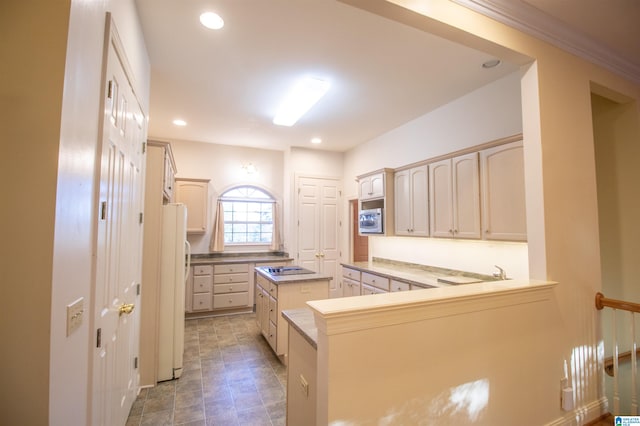 kitchen with light brown cabinetry, stainless steel microwave, white fridge, and kitchen peninsula