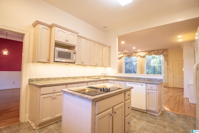 kitchen featuring dishwasher, dark wood-type flooring, a kitchen island, and black electric stovetop