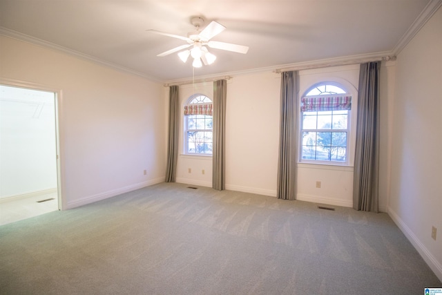 carpeted empty room featuring a wealth of natural light, ceiling fan, and crown molding