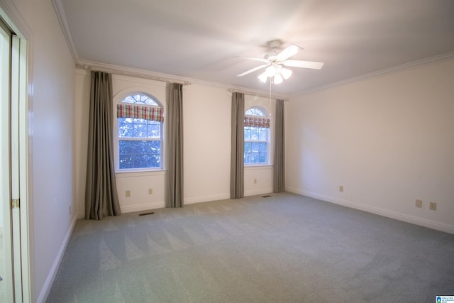 empty room featuring ceiling fan, light colored carpet, and ornamental molding