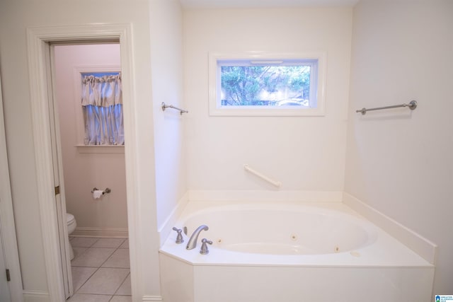 bathroom with tile patterned floors, a washtub, and toilet