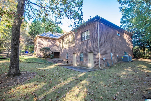 rear view of house featuring a patio, a yard, and central air condition unit