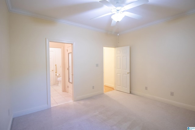 unfurnished bedroom featuring ceiling fan, ensuite bath, crown molding, and light colored carpet