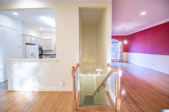 staircase featuring hardwood / wood-style flooring and ornamental molding