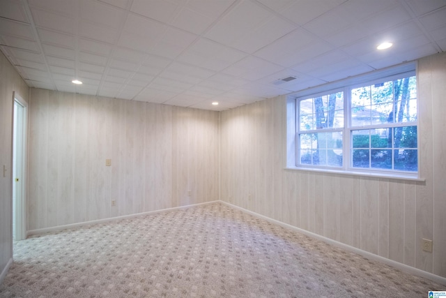 carpeted empty room featuring a paneled ceiling