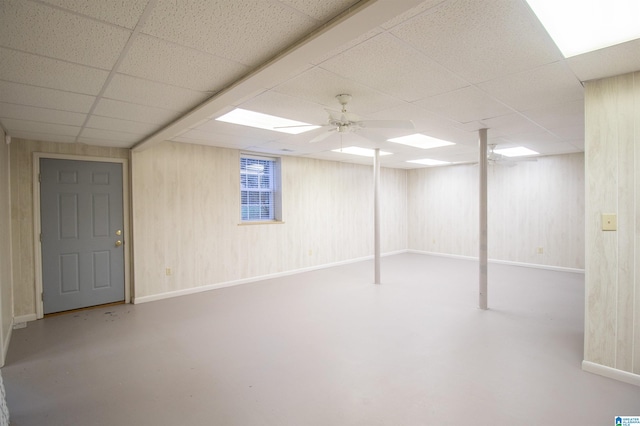 basement featuring a paneled ceiling and ceiling fan