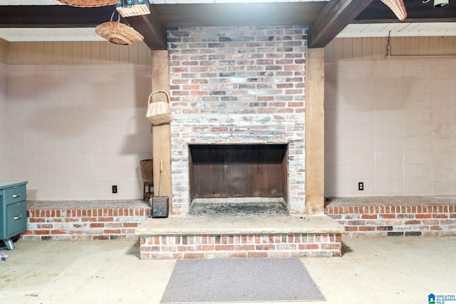 details featuring a fireplace, beamed ceiling, and concrete floors