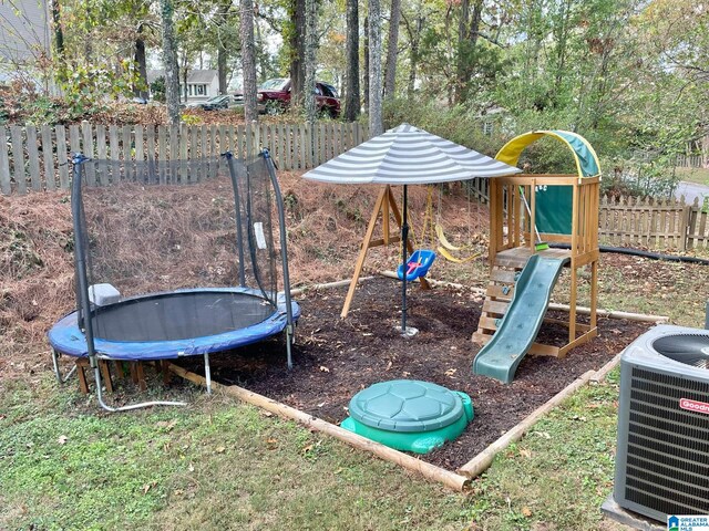 view of jungle gym featuring central air condition unit and a trampoline