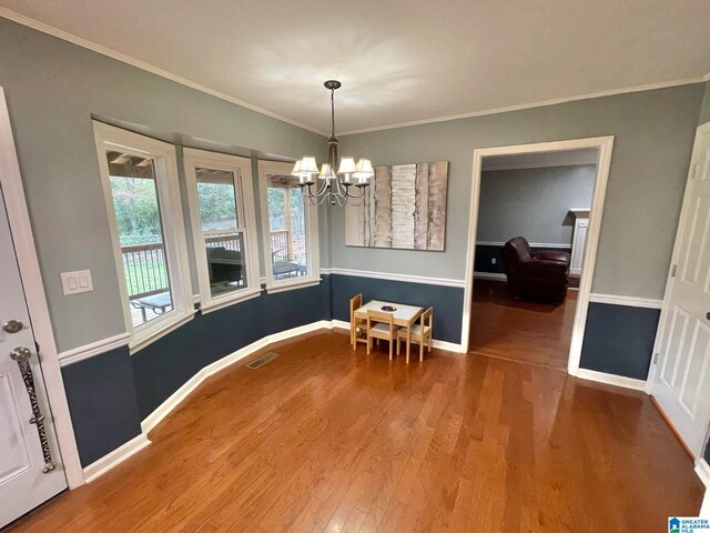 dining room featuring ornamental molding, a notable chandelier, and hardwood / wood-style flooring