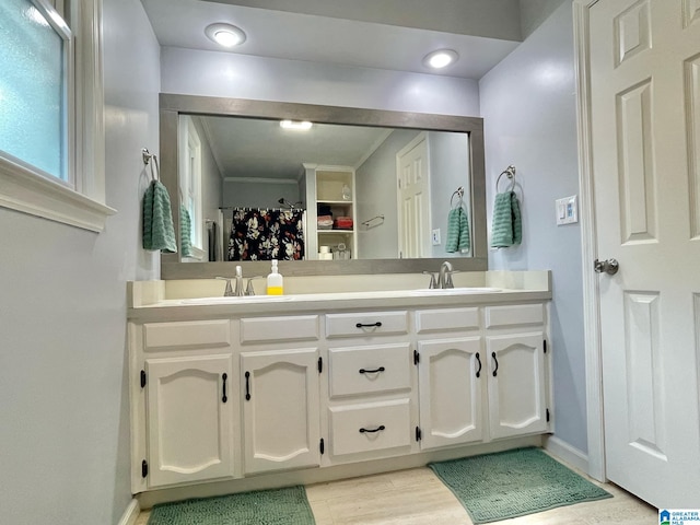 bathroom with vanity, hardwood / wood-style flooring, and crown molding