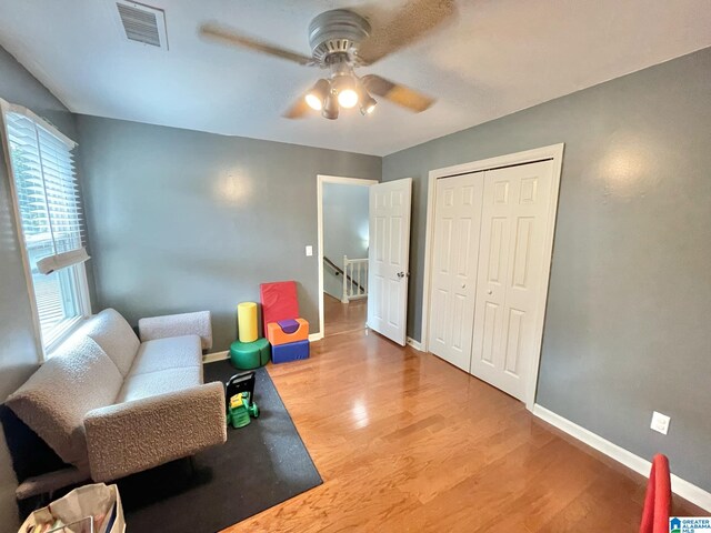 sitting room with hardwood / wood-style flooring and ceiling fan