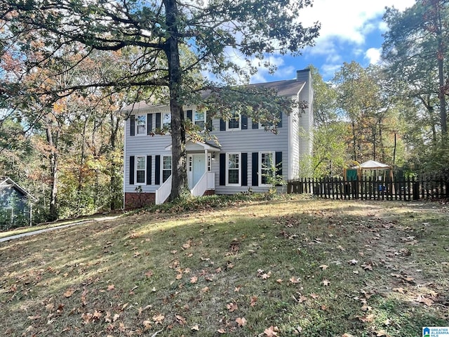 colonial home featuring a front lawn and a gazebo