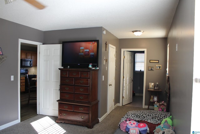 bedroom with ceiling fan, connected bathroom, and carpet floors