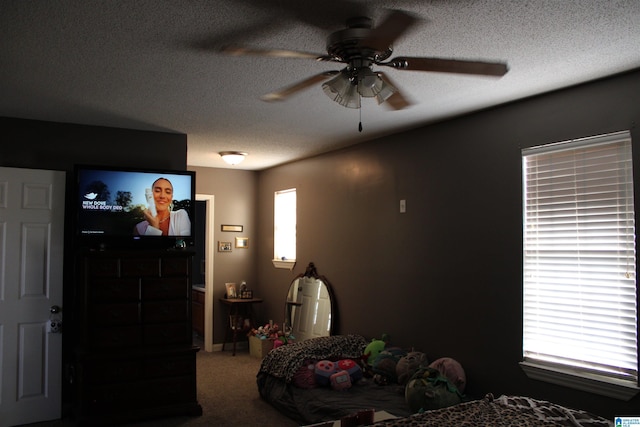 carpeted cinema room featuring a textured ceiling and ceiling fan