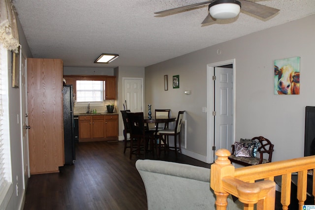 living room featuring sink, a textured ceiling, ceiling fan, and dark hardwood / wood-style floors