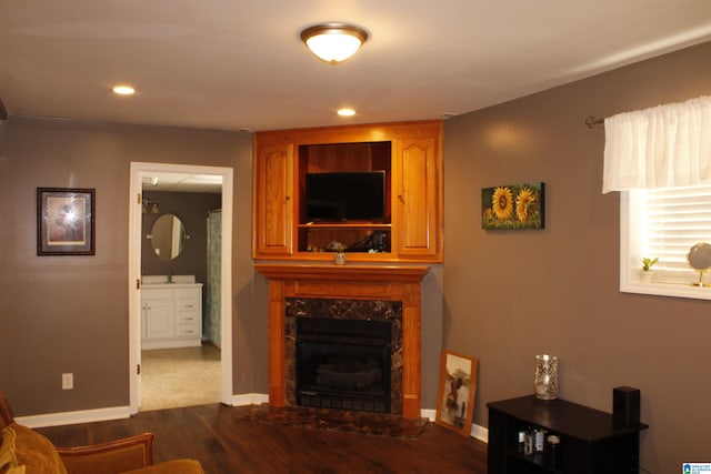 living room with a high end fireplace and hardwood / wood-style floors