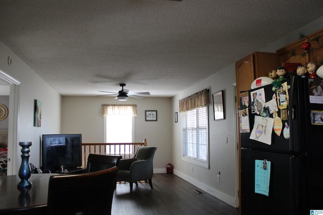 dining space with a textured ceiling, ceiling fan, and dark hardwood / wood-style floors