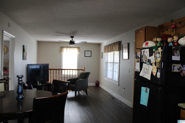 dining space with ceiling fan, dark hardwood / wood-style floors, and a textured ceiling