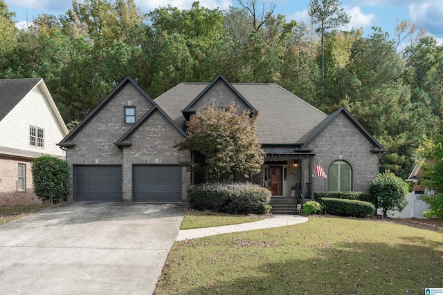 french country style house featuring a garage and a front yard