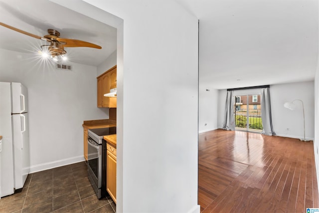 kitchen with white refrigerator, ceiling fan, stainless steel range with electric cooktop, and dark hardwood / wood-style flooring