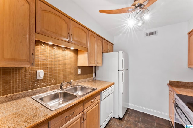 kitchen with tasteful backsplash, dark tile patterned floors, sink, white appliances, and ceiling fan