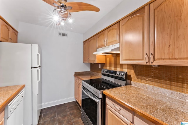 kitchen featuring light brown cabinets, white appliances, backsplash, and dark tile patterned flooring