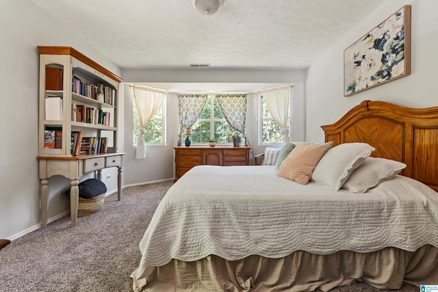 carpeted bedroom with a textured ceiling and multiple windows