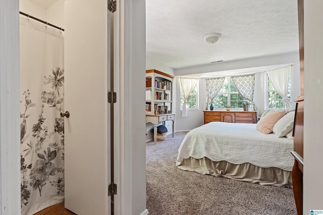 carpeted bedroom featuring a textured ceiling