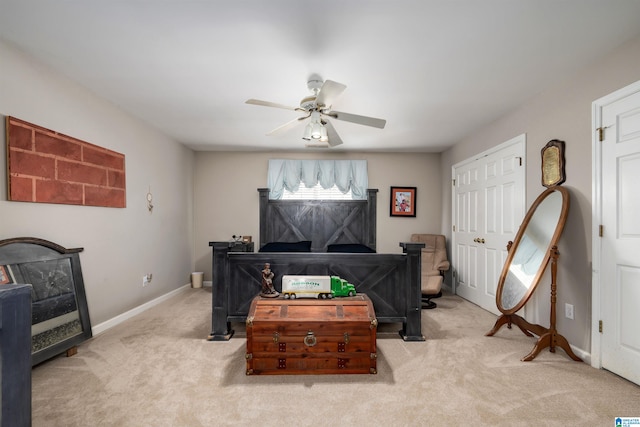 bedroom with ceiling fan, light carpet, and a closet