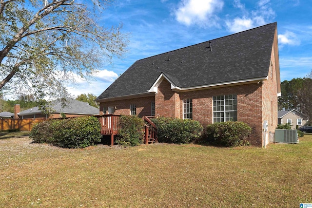 view of front of property with central AC, a front yard, and a deck