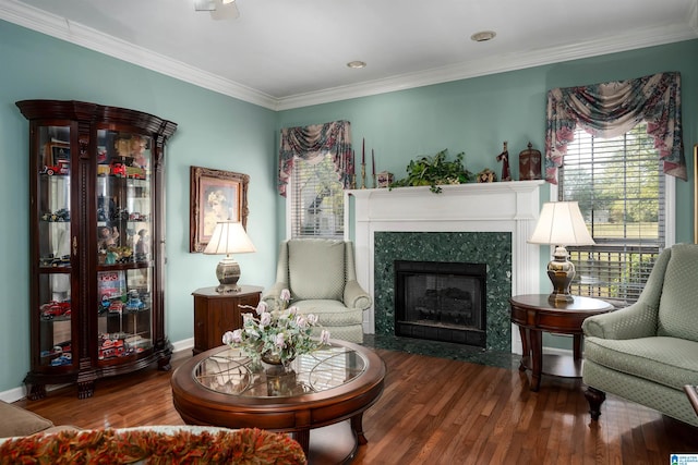 living area with hardwood / wood-style floors, ornamental molding, and a fireplace