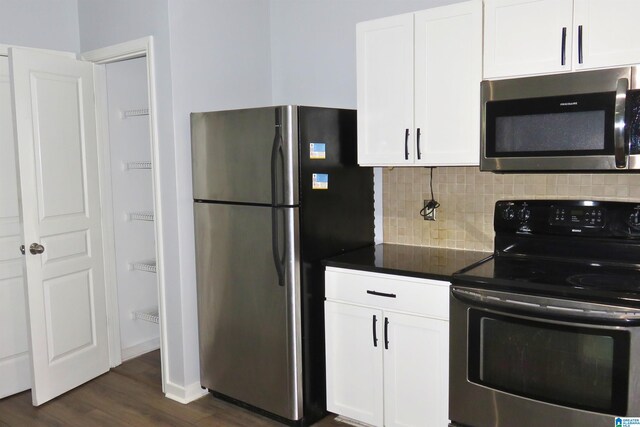 kitchen featuring white cabinets, decorative backsplash, dark wood-type flooring, and appliances with stainless steel finishes