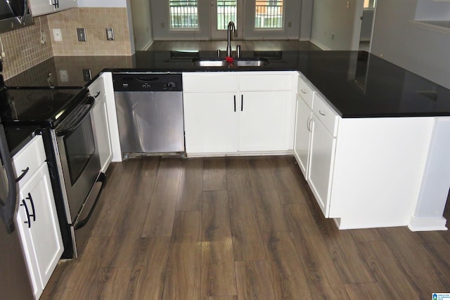 kitchen with kitchen peninsula, sink, dark hardwood / wood-style floors, white cabinetry, and appliances with stainless steel finishes