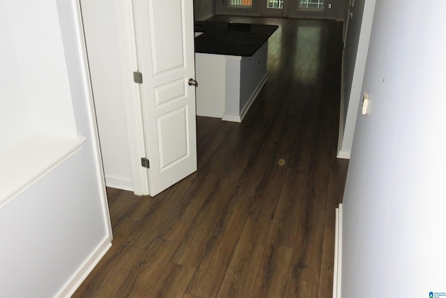 corridor with dark hardwood / wood-style flooring